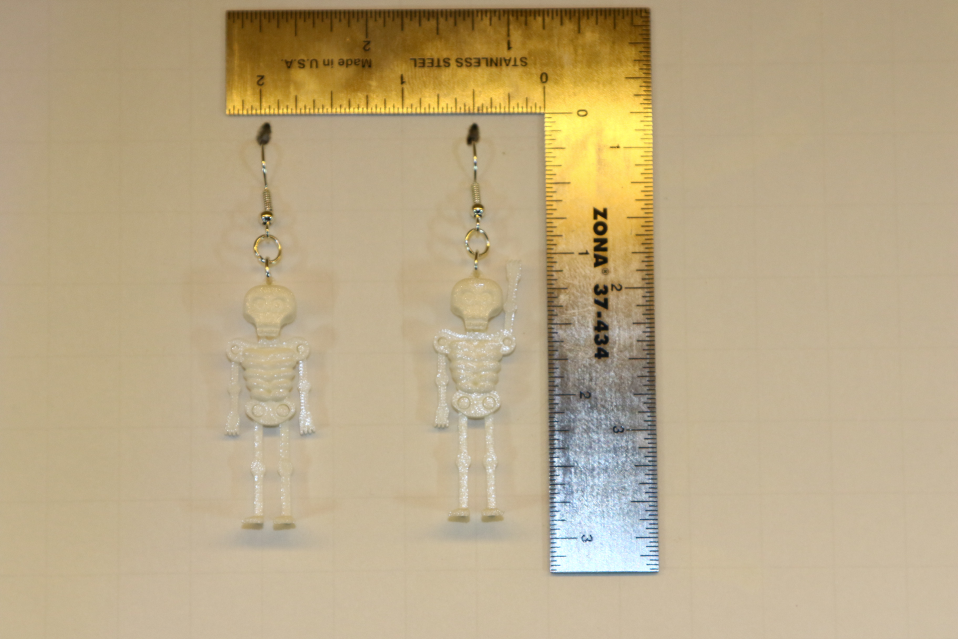 Skeleton-themed earrings with detailed skull and bone design