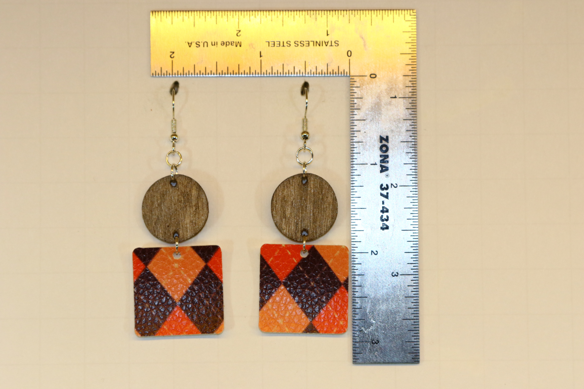 Wood and faux leather print earrings with mixed textures.