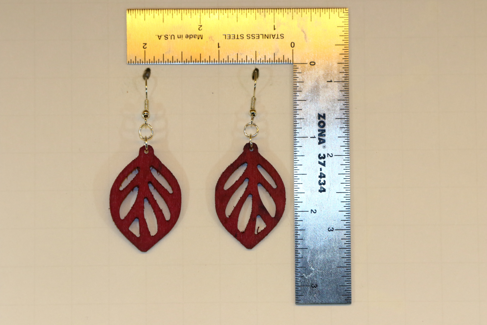 Wooden leaf-shaped earrings with cutout detailing.