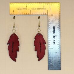 Wooden feather earrings with detailed carved feather design.