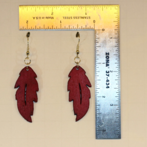 Wooden feather earrings with detailed carved feather design.