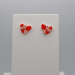Pair of stud earrings featuring nested layered heart designs.