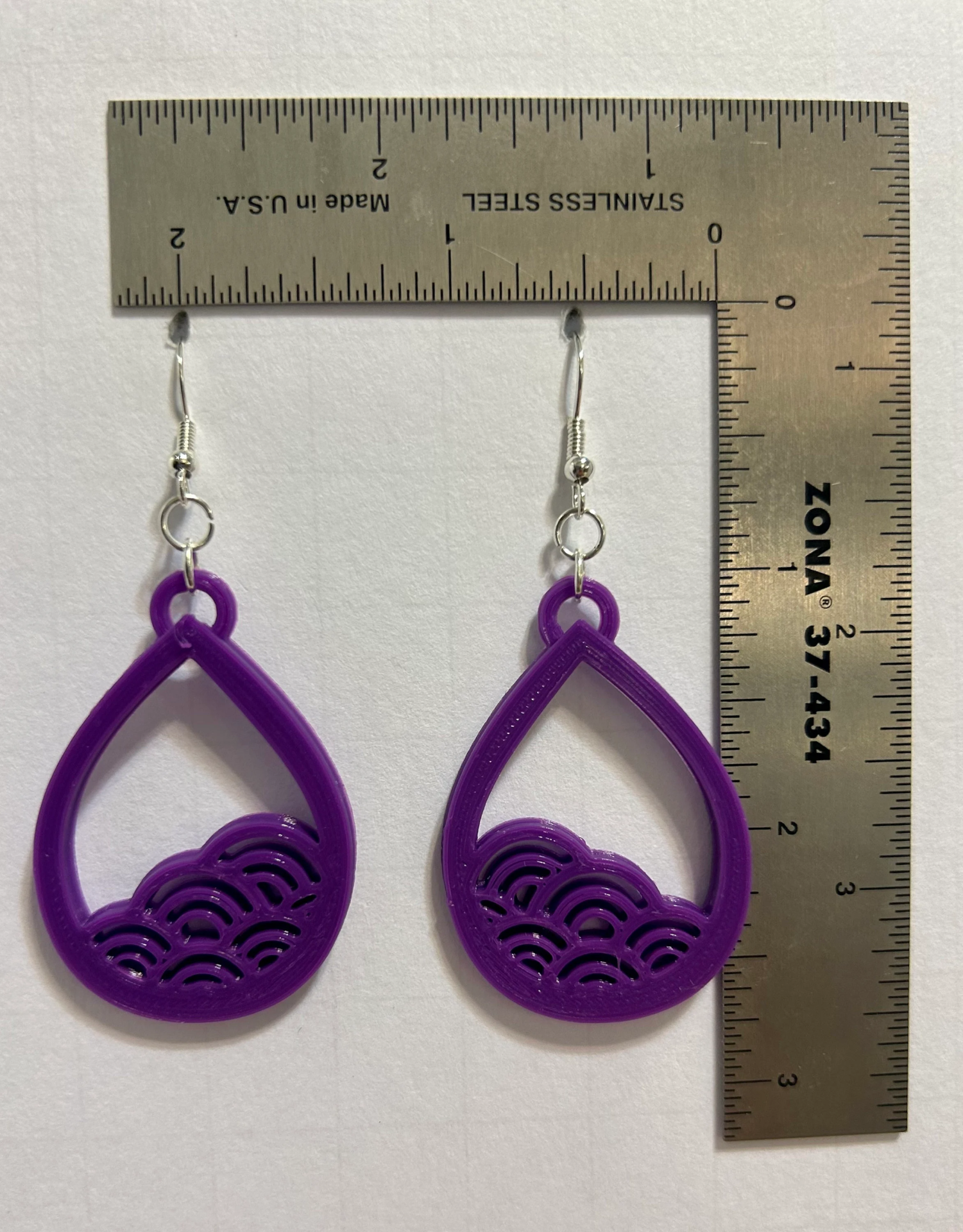 Earrings with curved wave design symbolizing ocean flow.