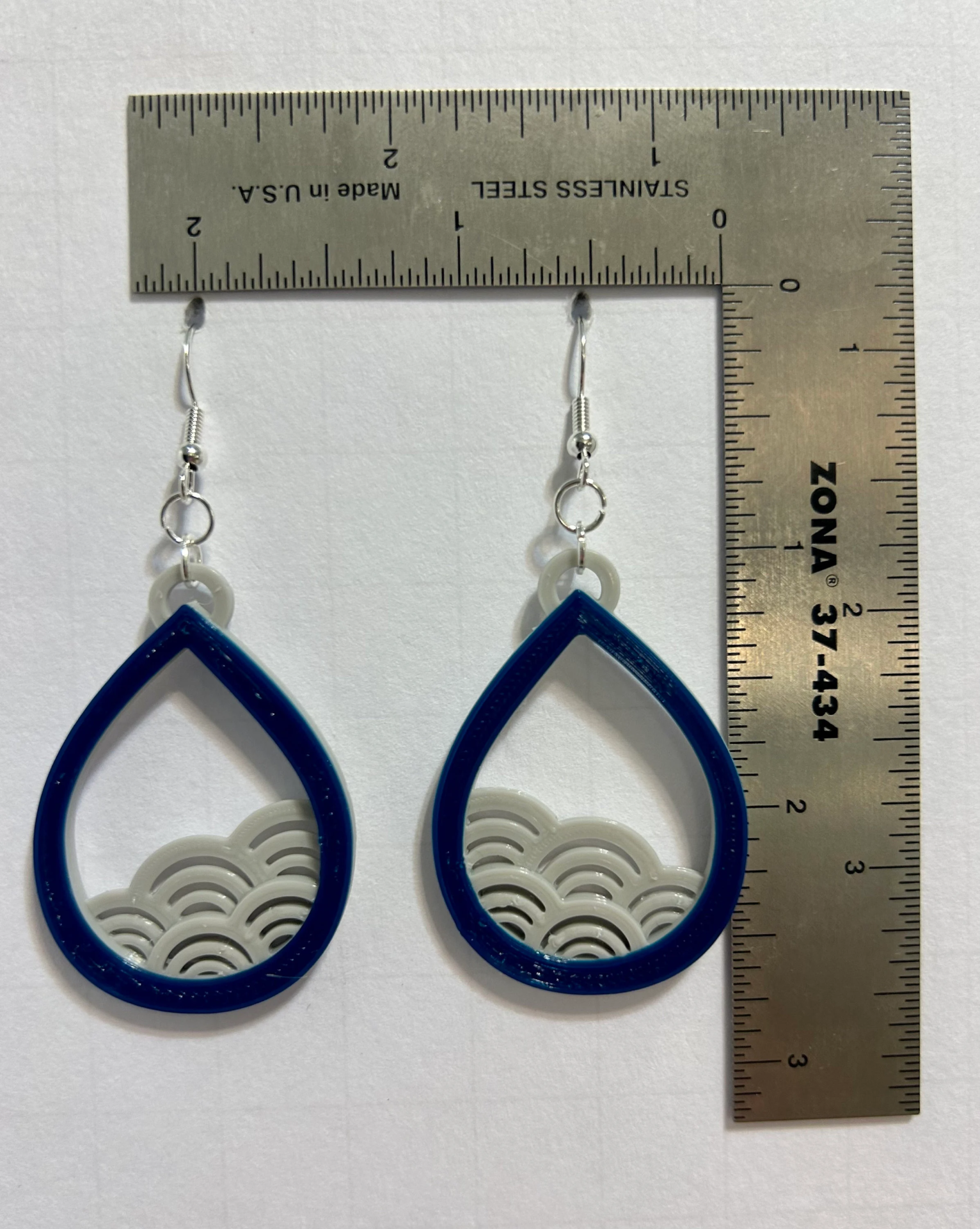 Earrings with curved wave design symbolizing ocean flow.