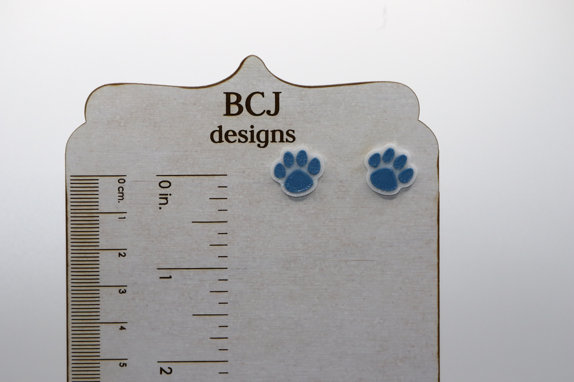 Paw print stud earrings featuring simple paw design