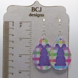 Glitter-covered bunny-shaped earrings in bright pastel colors.