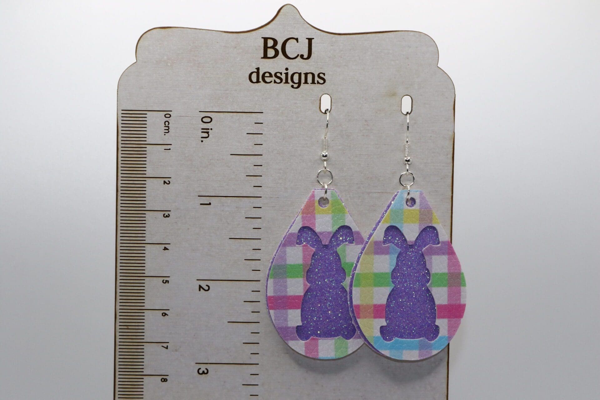 Glitter-covered bunny-shaped earrings in bright pastel colors.