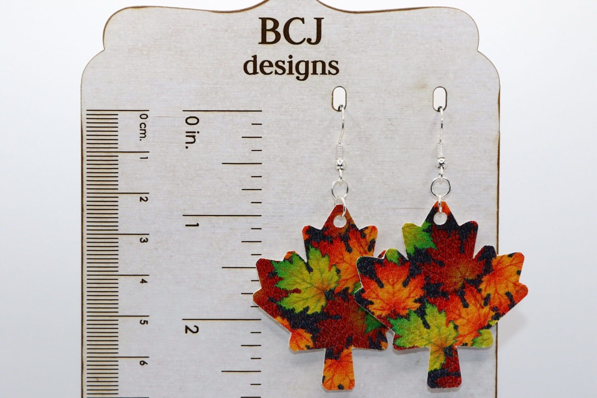 Earrings shaped like autumn-colored faux leather maple leaves
