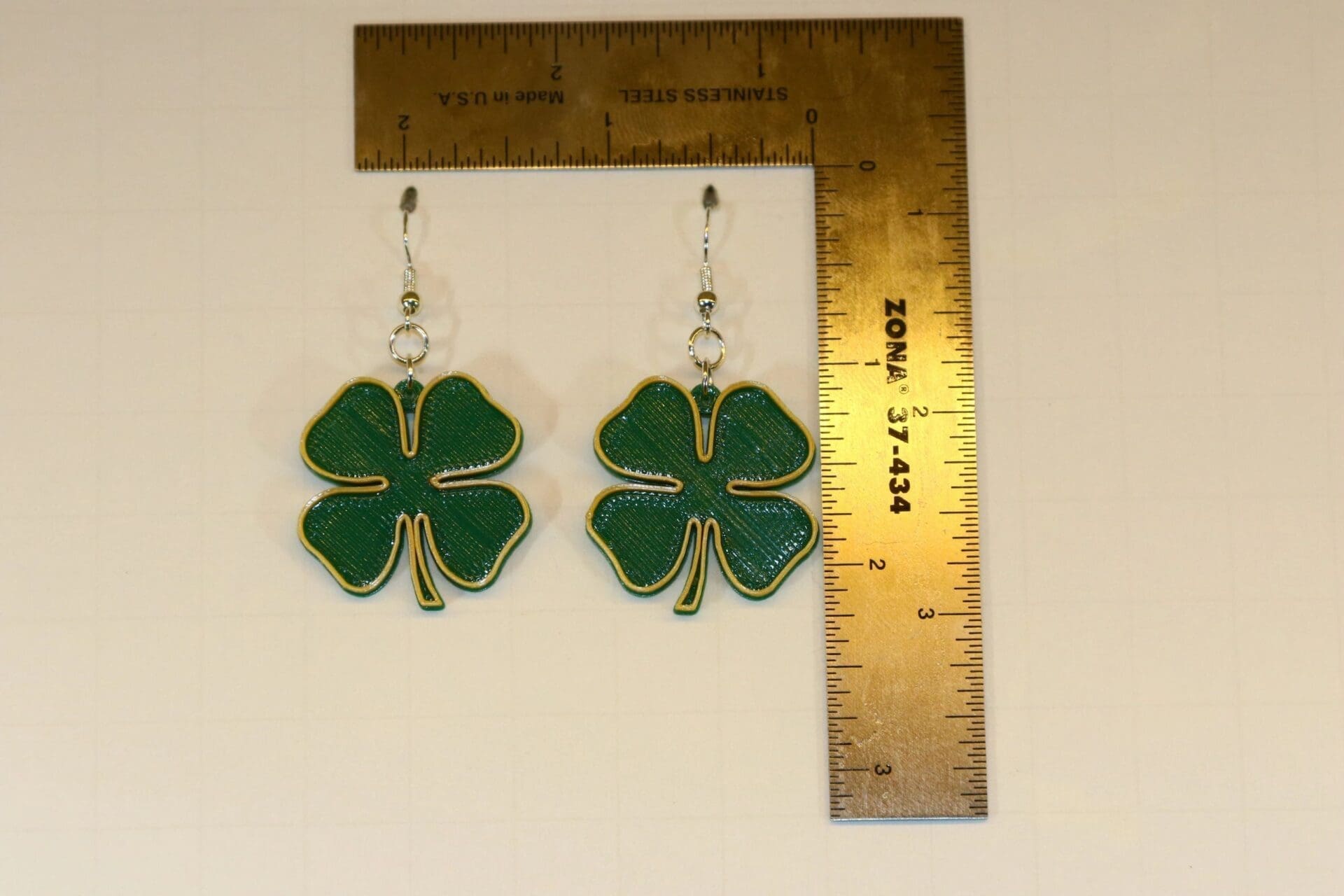 Pair of earrings featuring green clovers with gold accent details.