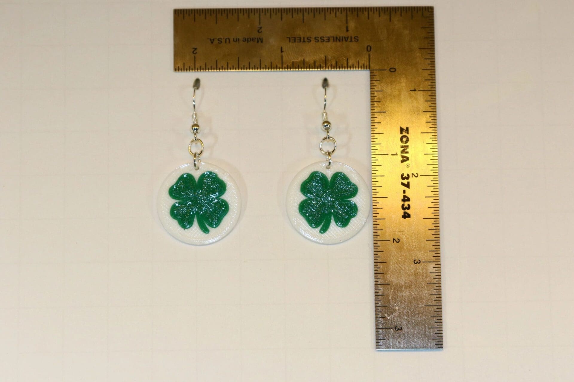 Pair of earrings shaped like green and white clovers.