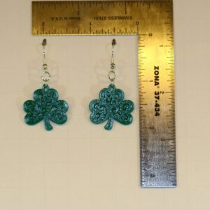 Pair of earrings featuring a swirling green shamrock design.