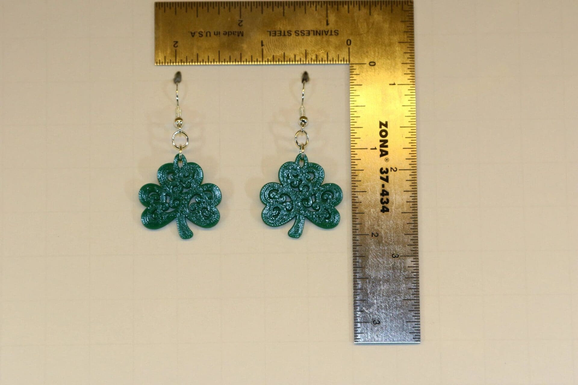 Pair of earrings featuring a swirling green shamrock design.