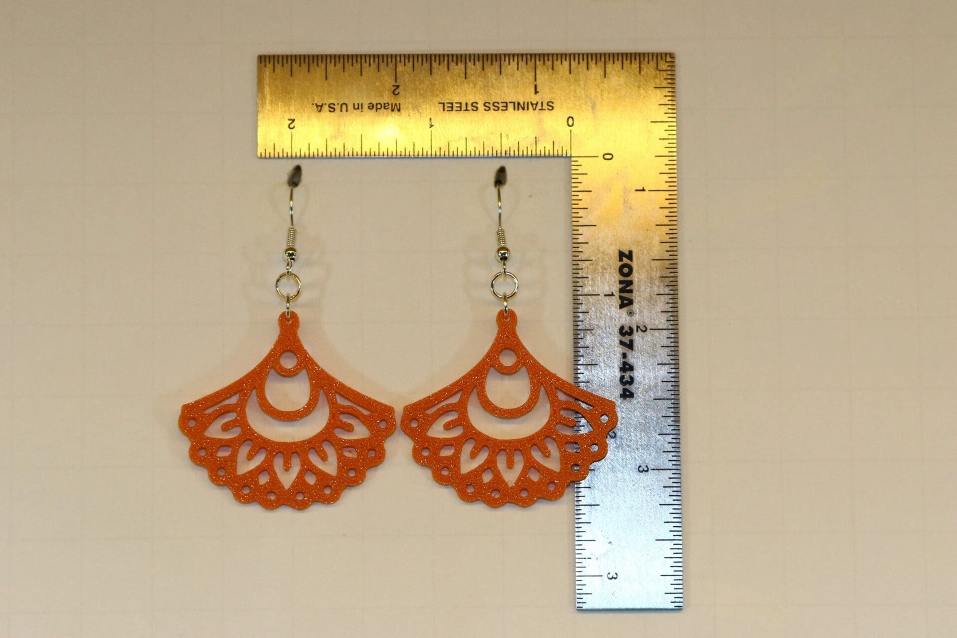 mandala fan earring on a display for size