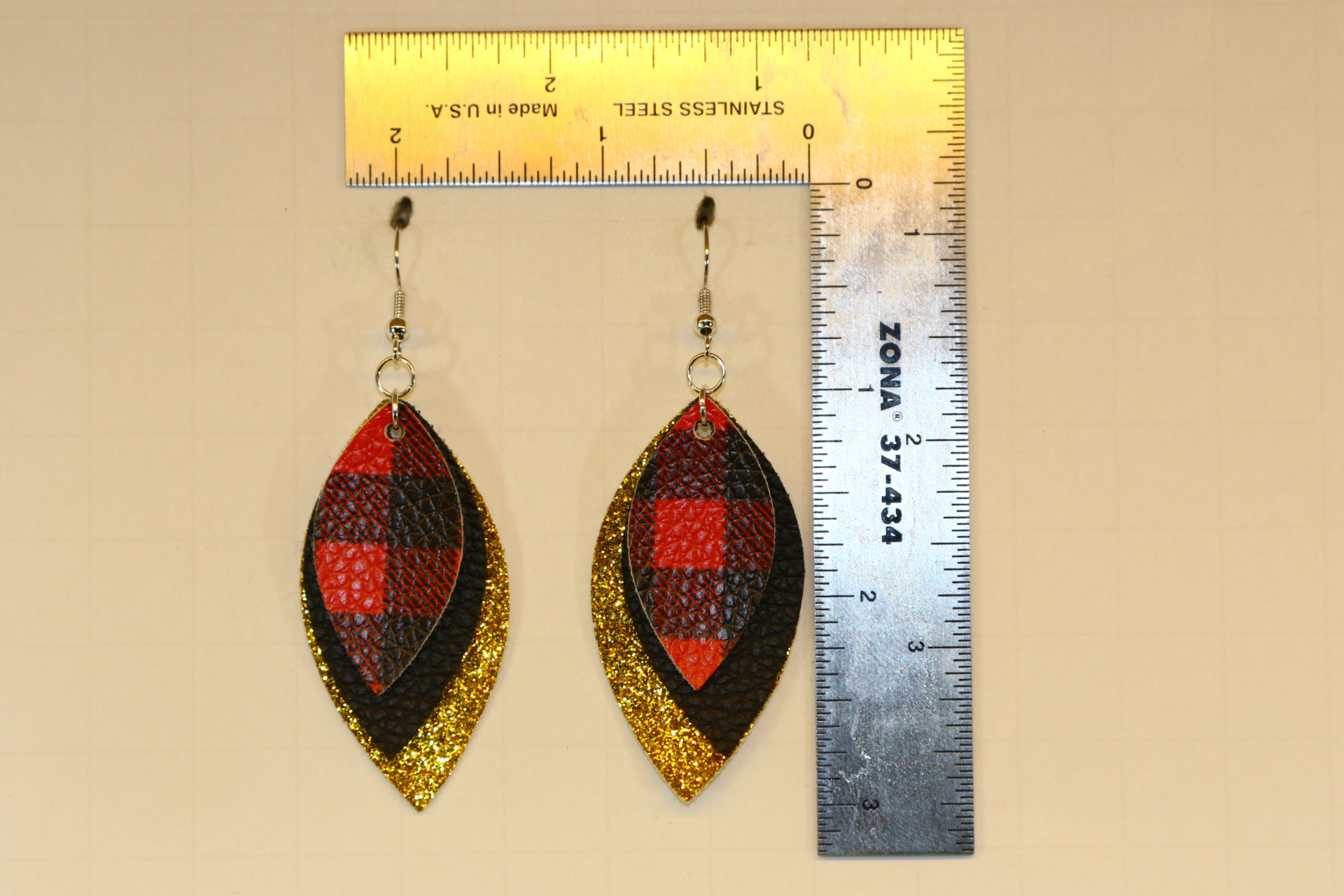 Plaid and glitter faux leather earrings with festive shine.