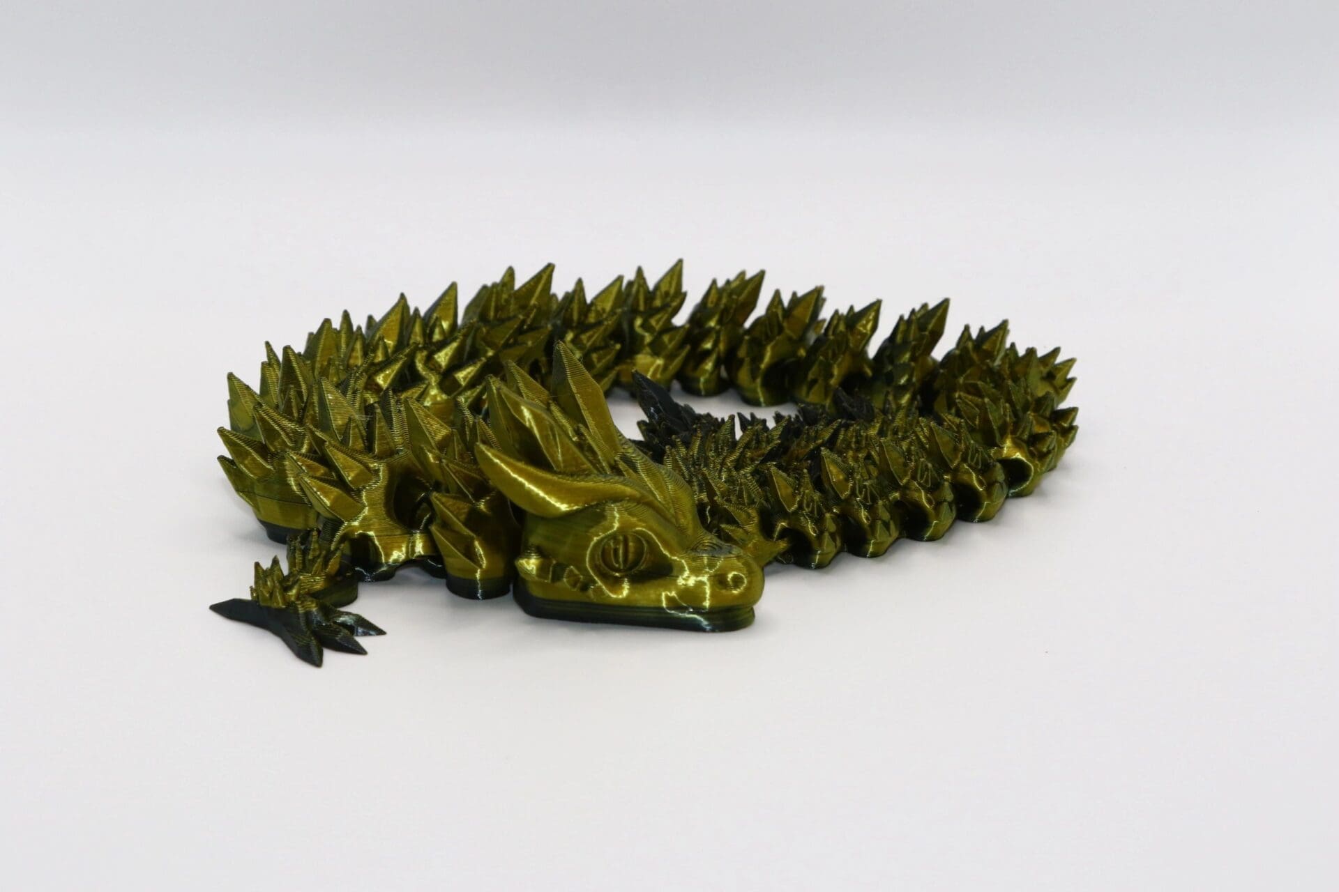 Articulated dragon fidget toy with movable segmented body and detailed head.Articulated dragon fidget toy with movable segmented body and detailed head.