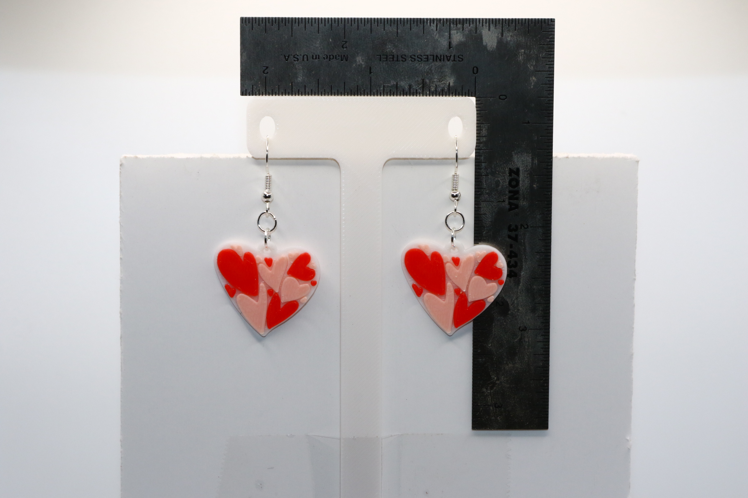 pair of dangler earrings that have a heart full of smaller hearts