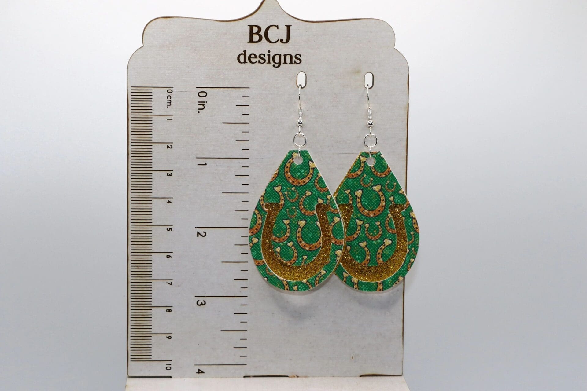 Pair of earrings shaped like bright green faux leather horseshoes.