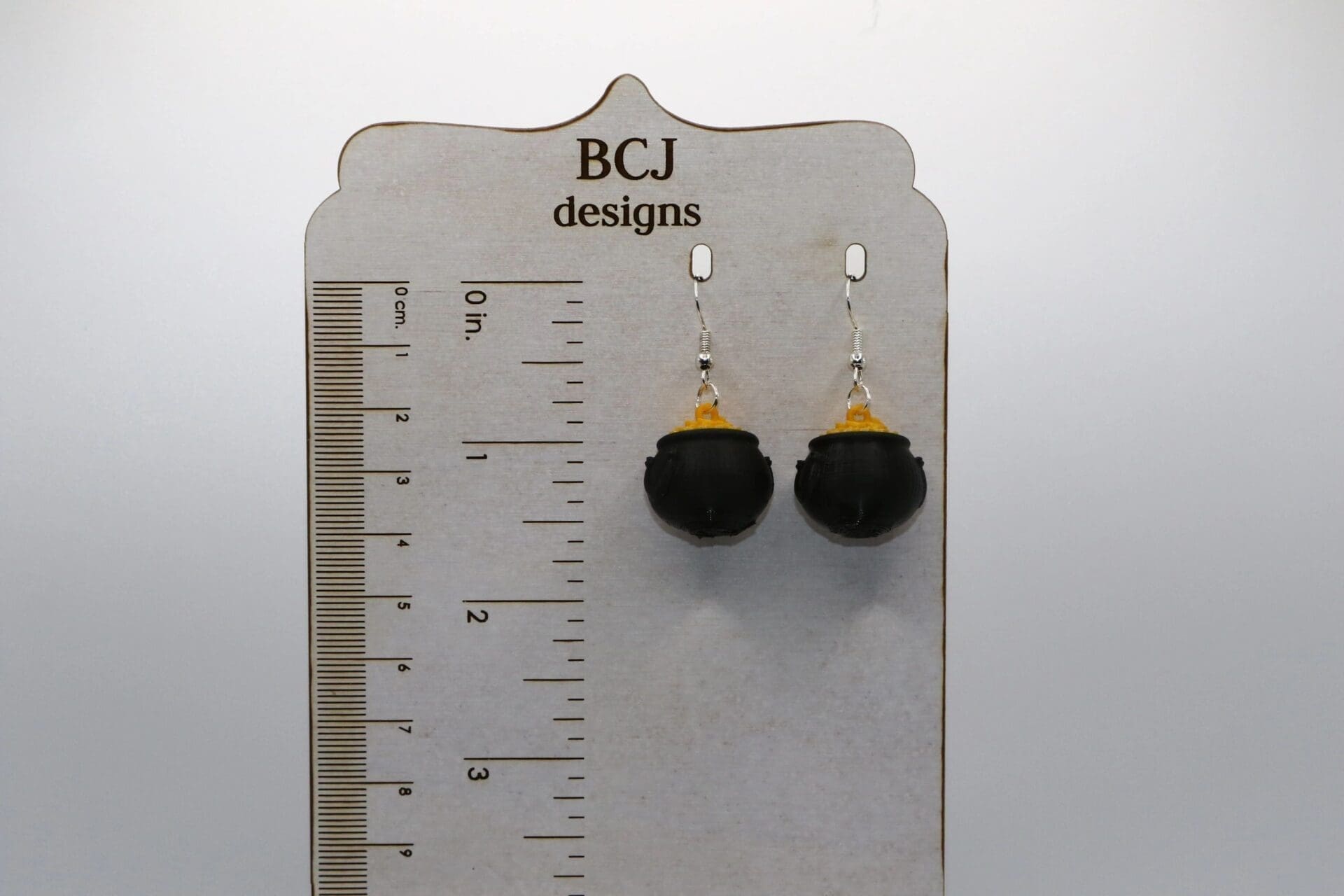 air of earrings featuring a pot of gold with rainbow details.