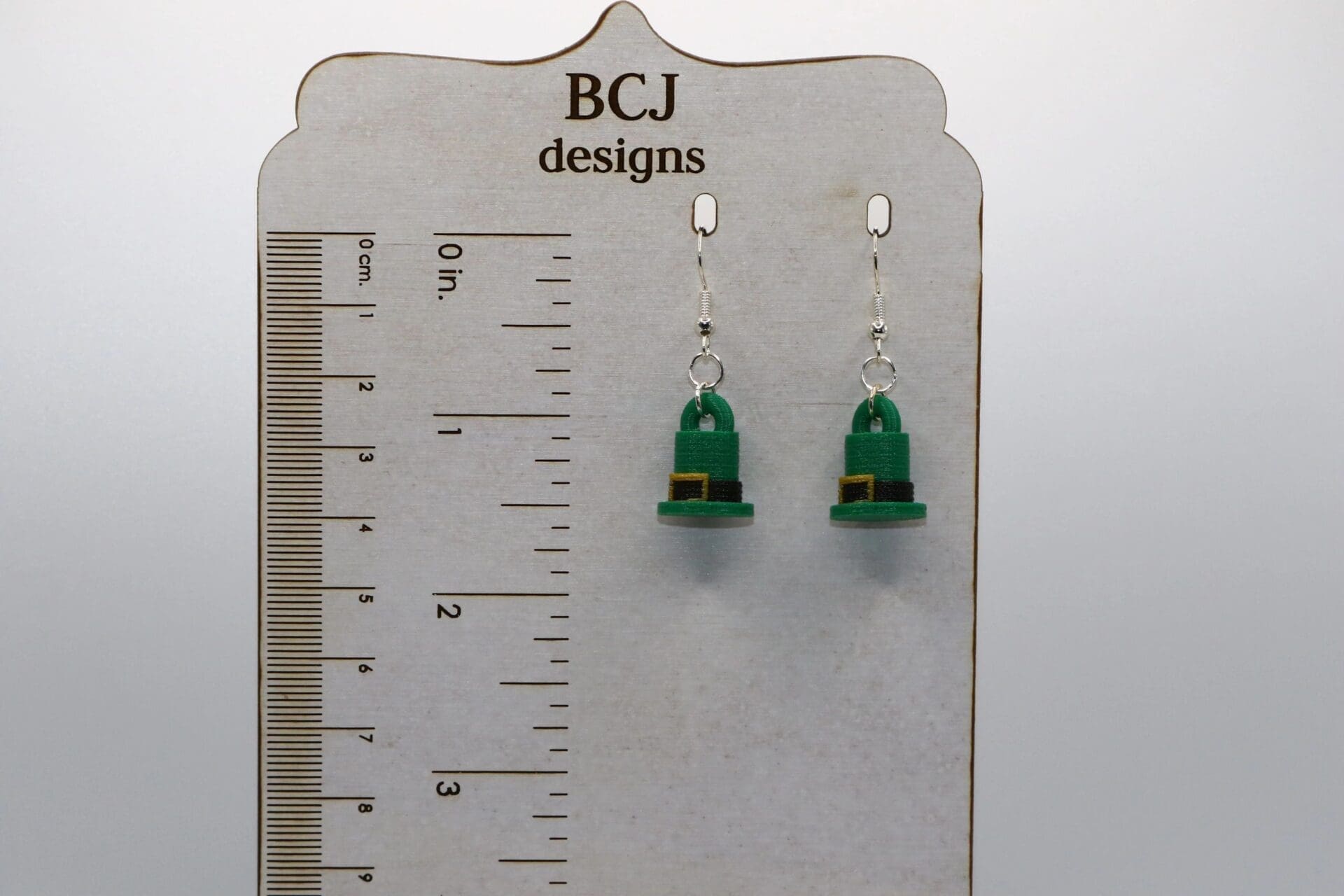 Pair of earrings shaped like green leprechaun top hats with gold buckles.