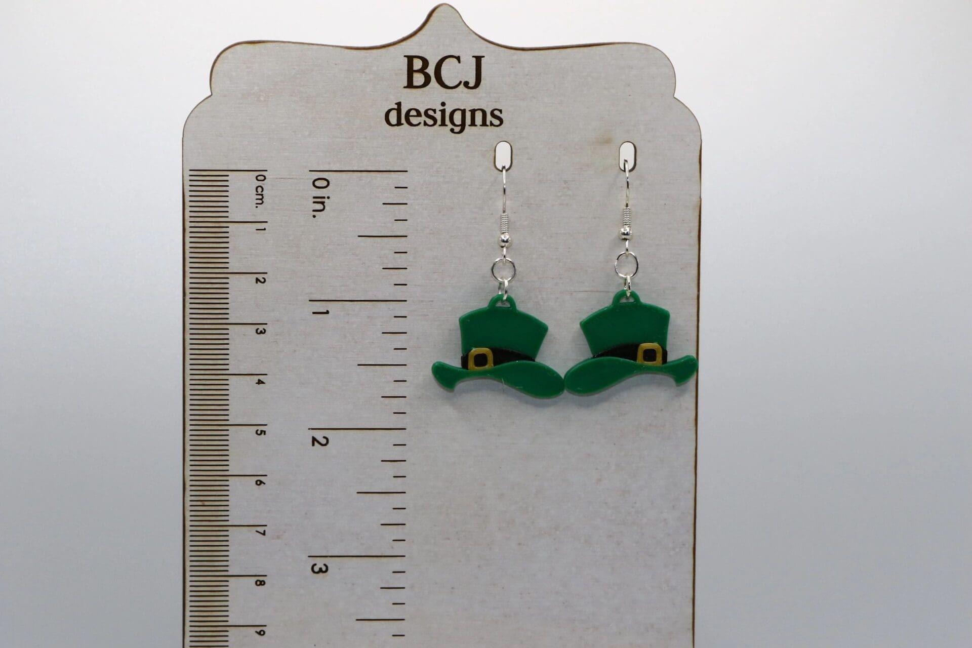 Pair of earrings shaped like green leprechaun hats with gold buckles.