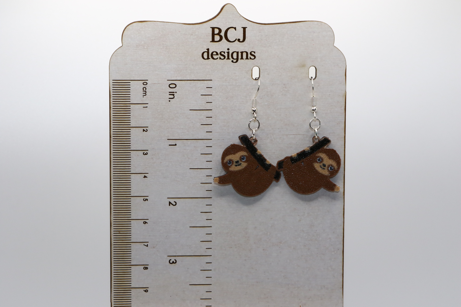 Sloth earrings featuring hanging sloth design.