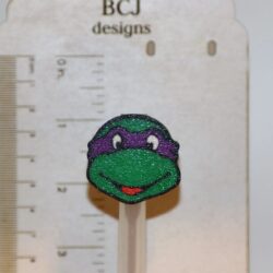 Ninja Turtle straw topper featuring green turtle face mask design.