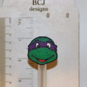 Ninja Turtle straw topper featuring green turtle face mask design.