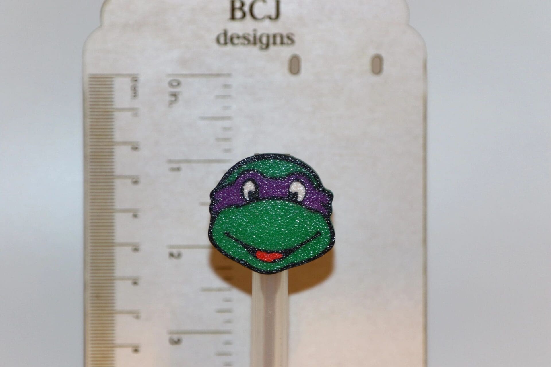 Ninja Turtle straw topper featuring green turtle face mask design.