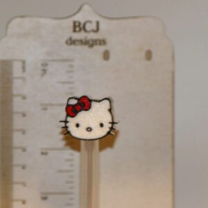 Hello Kitty straw topper with white face and red bow.