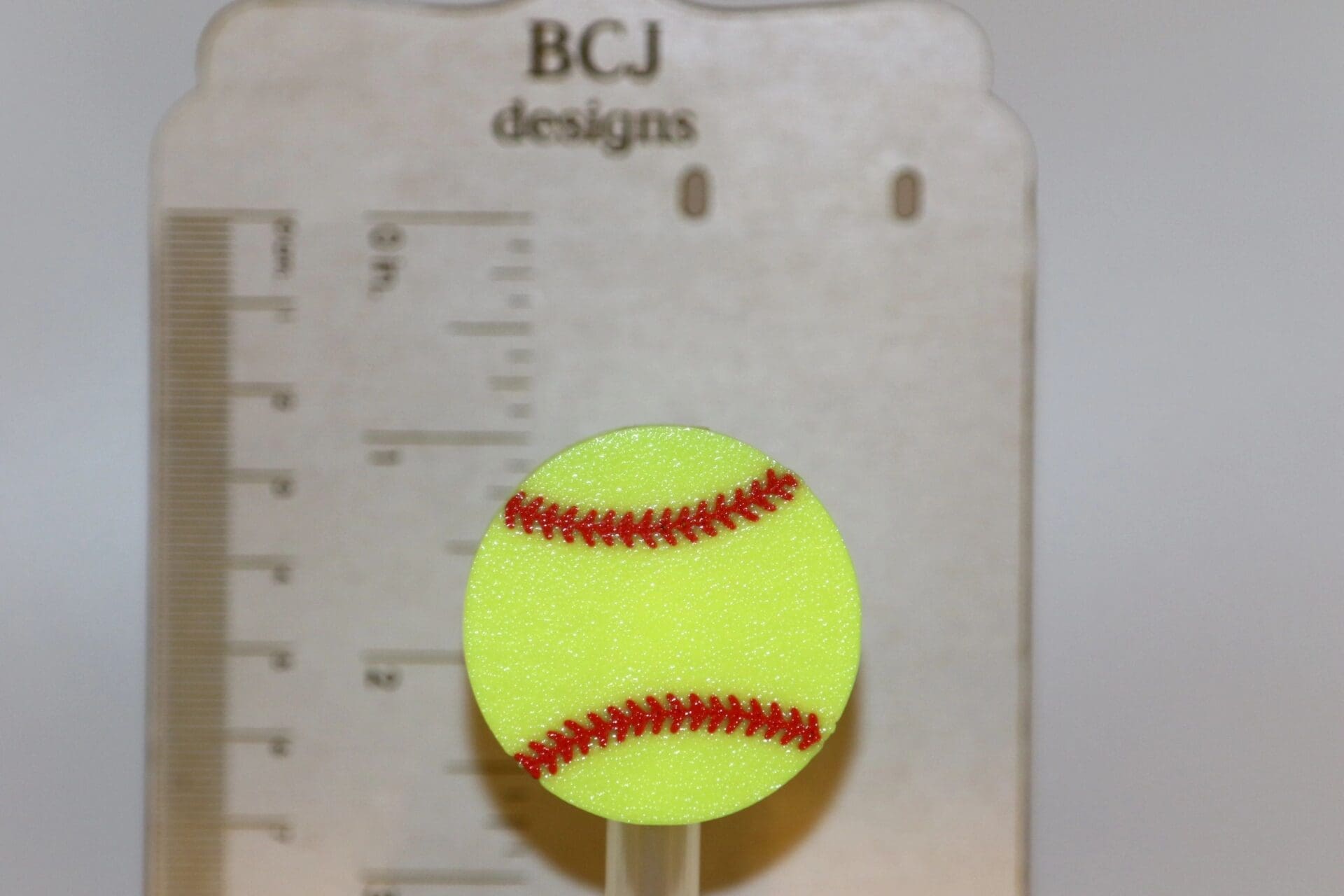 Softball straw topper with yellow ball and red stitch detailing.