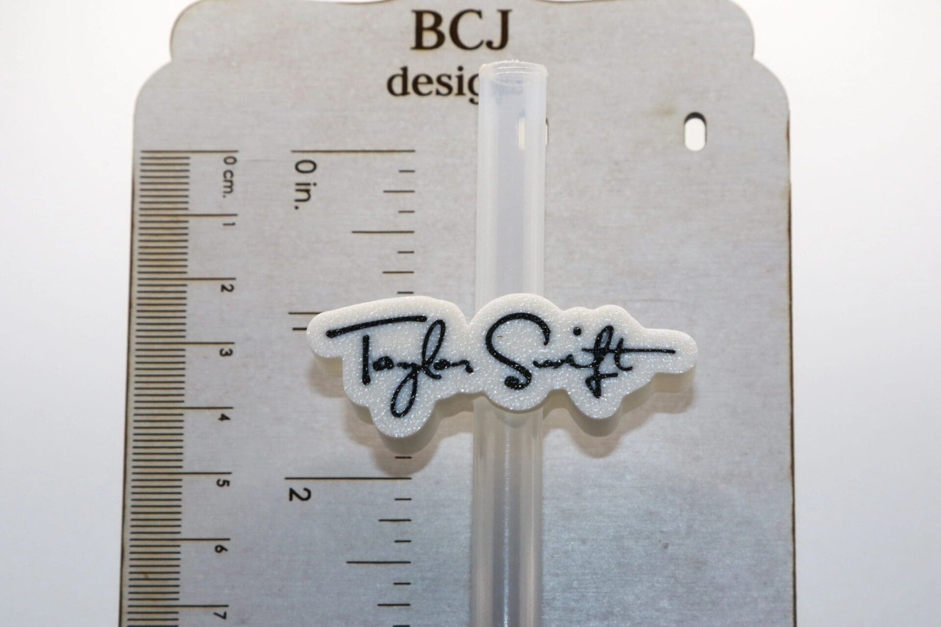 Taylor Swift signature straw topper clipped to a straw