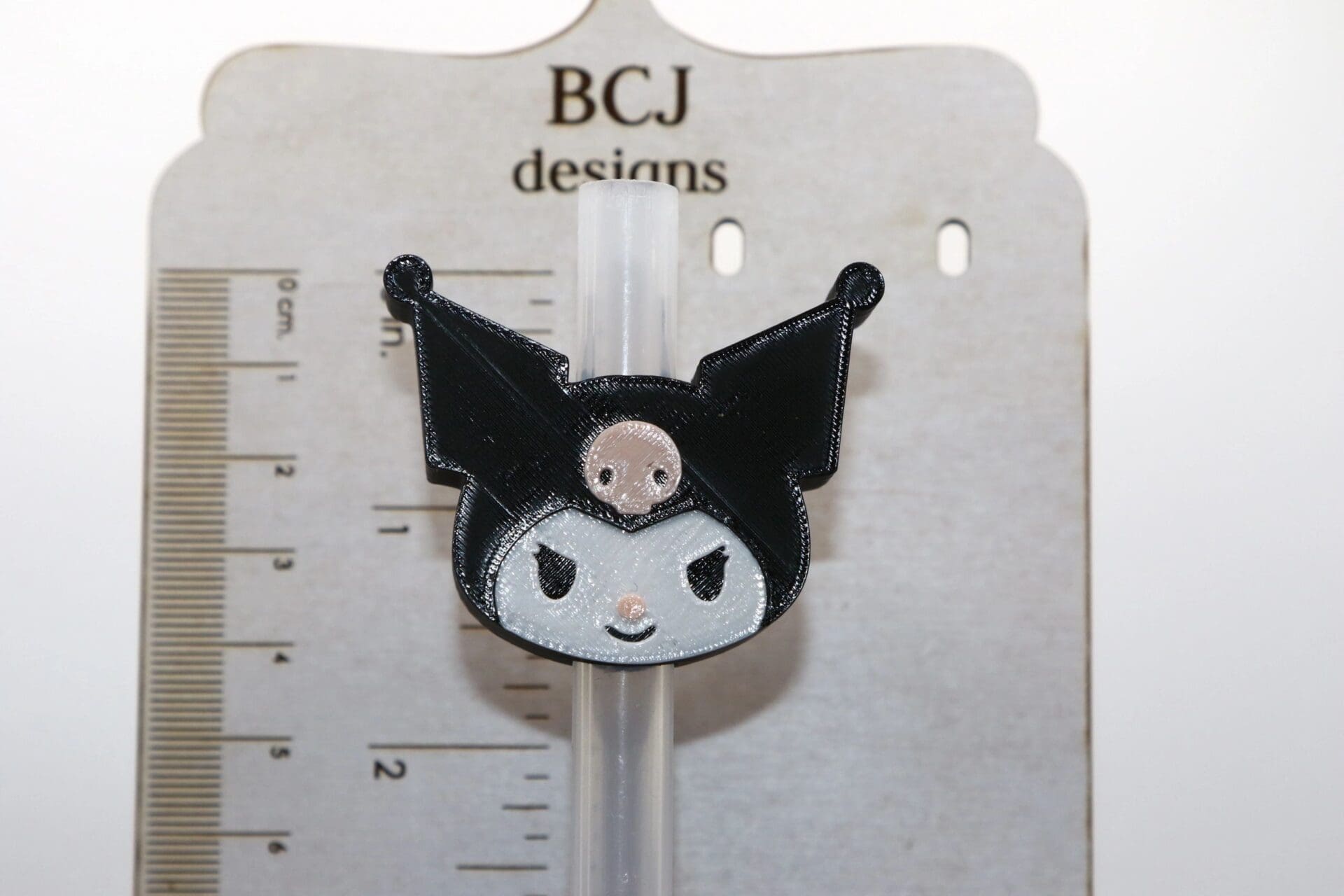 Kuromi straw topper with black hat and pink skull accent.