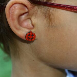pumpkin stud earrings on an ear