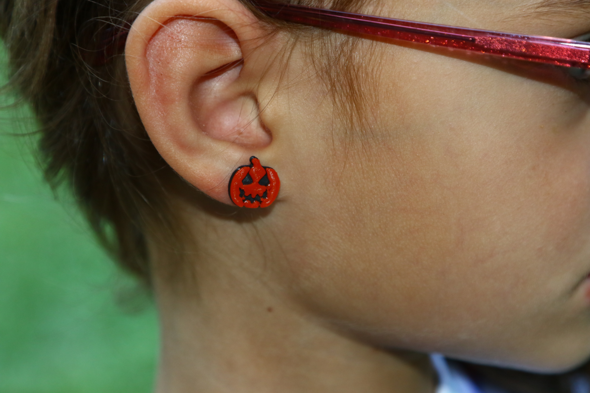 pumpkin stud earrings on an ear
