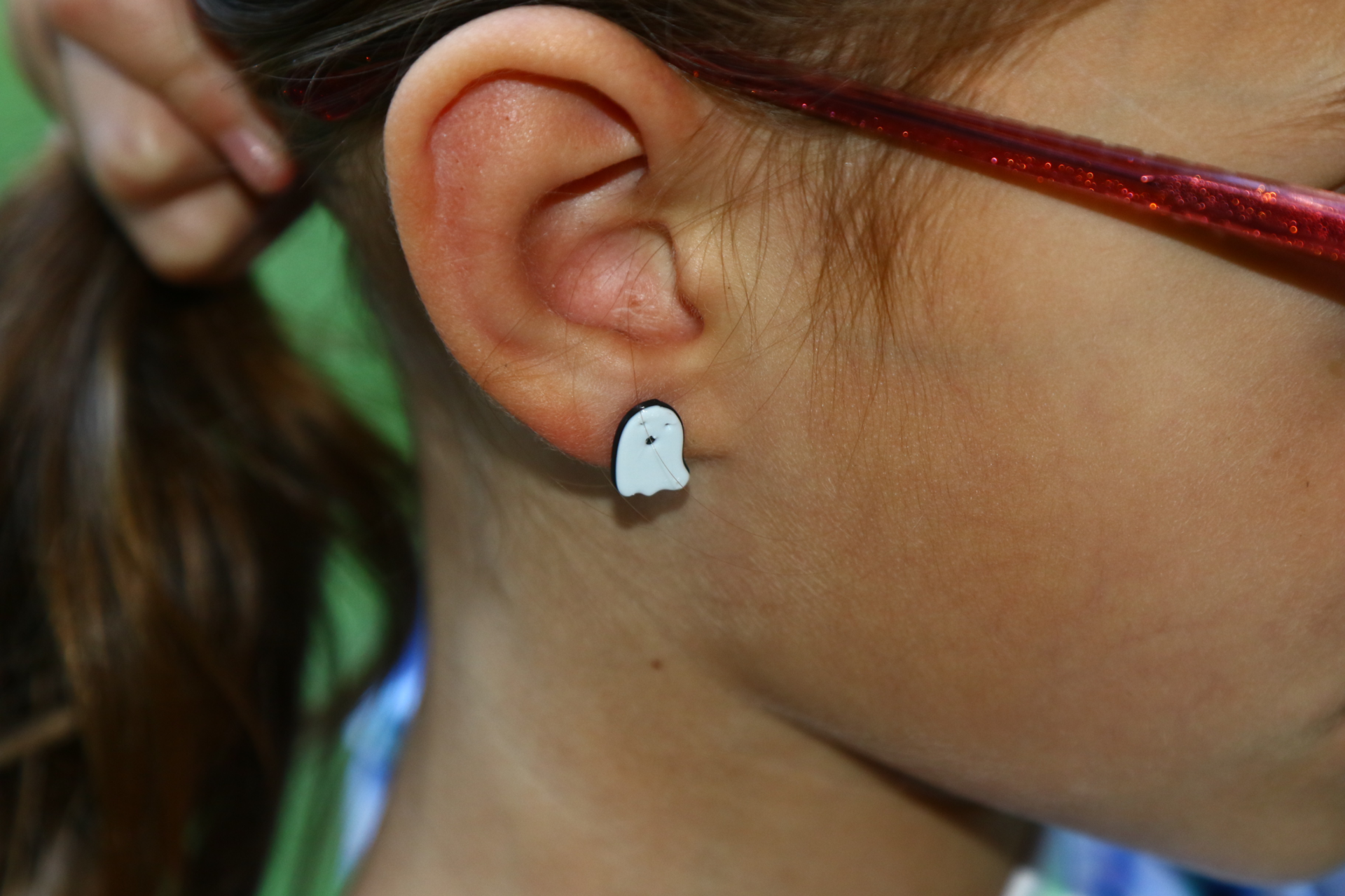 ghost stud earrings on an ear