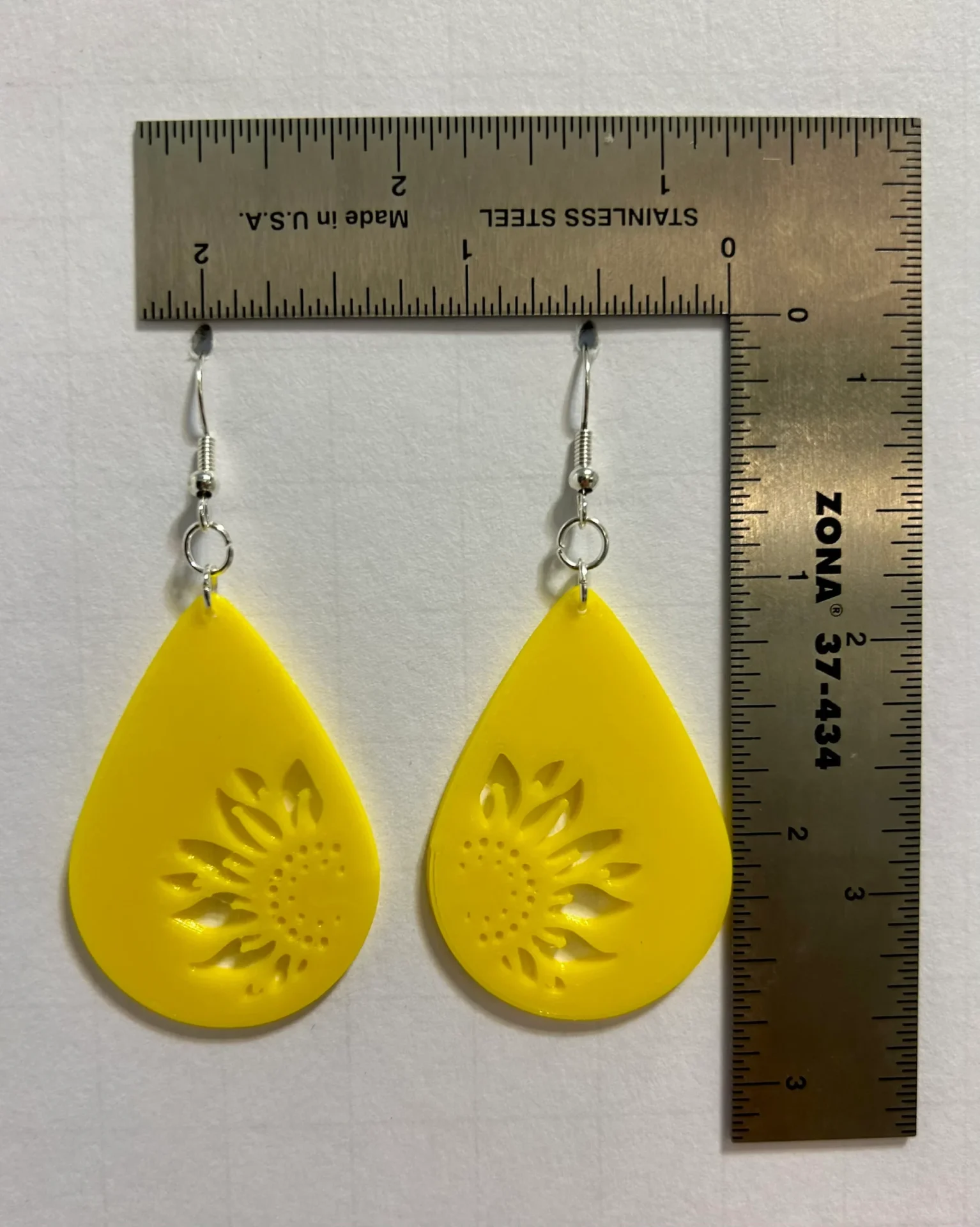 Teardrop sunflower earrings with detailed elongated design.