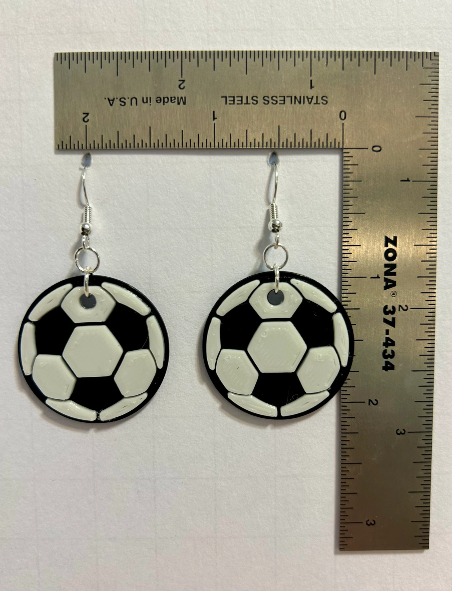 Pair of earrings shaped like a black-and-white soccer ball.