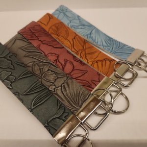 Lineup of Embossed wristlets collection showing multiple detailed embossed designs