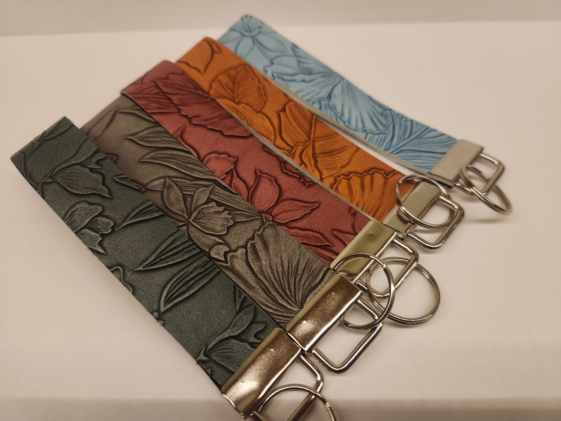 Lineup of Embossed wristlets collection showing multiple detailed embossed designs