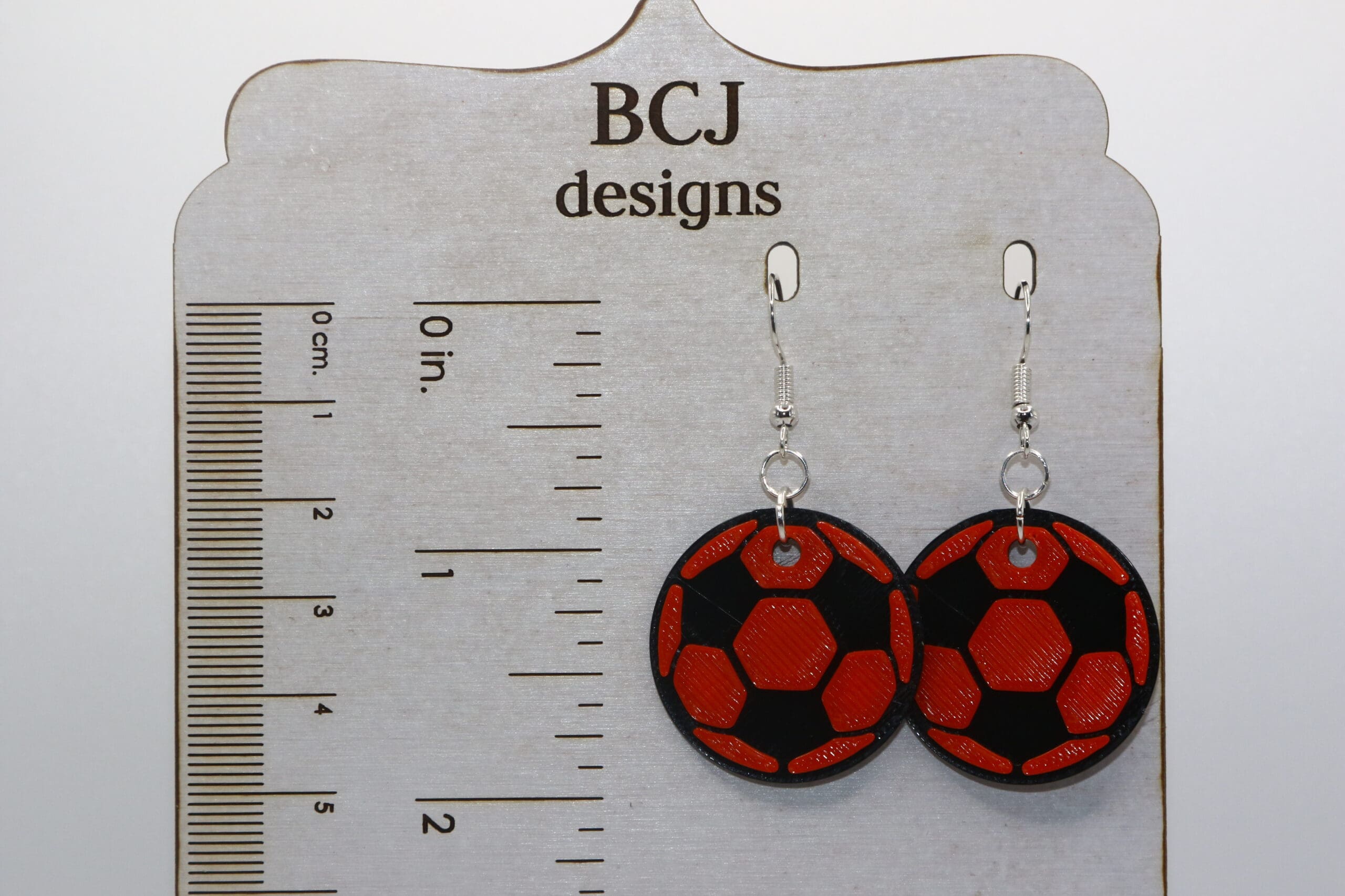 Black and orange soccer earrings showing Rising Sun team colors