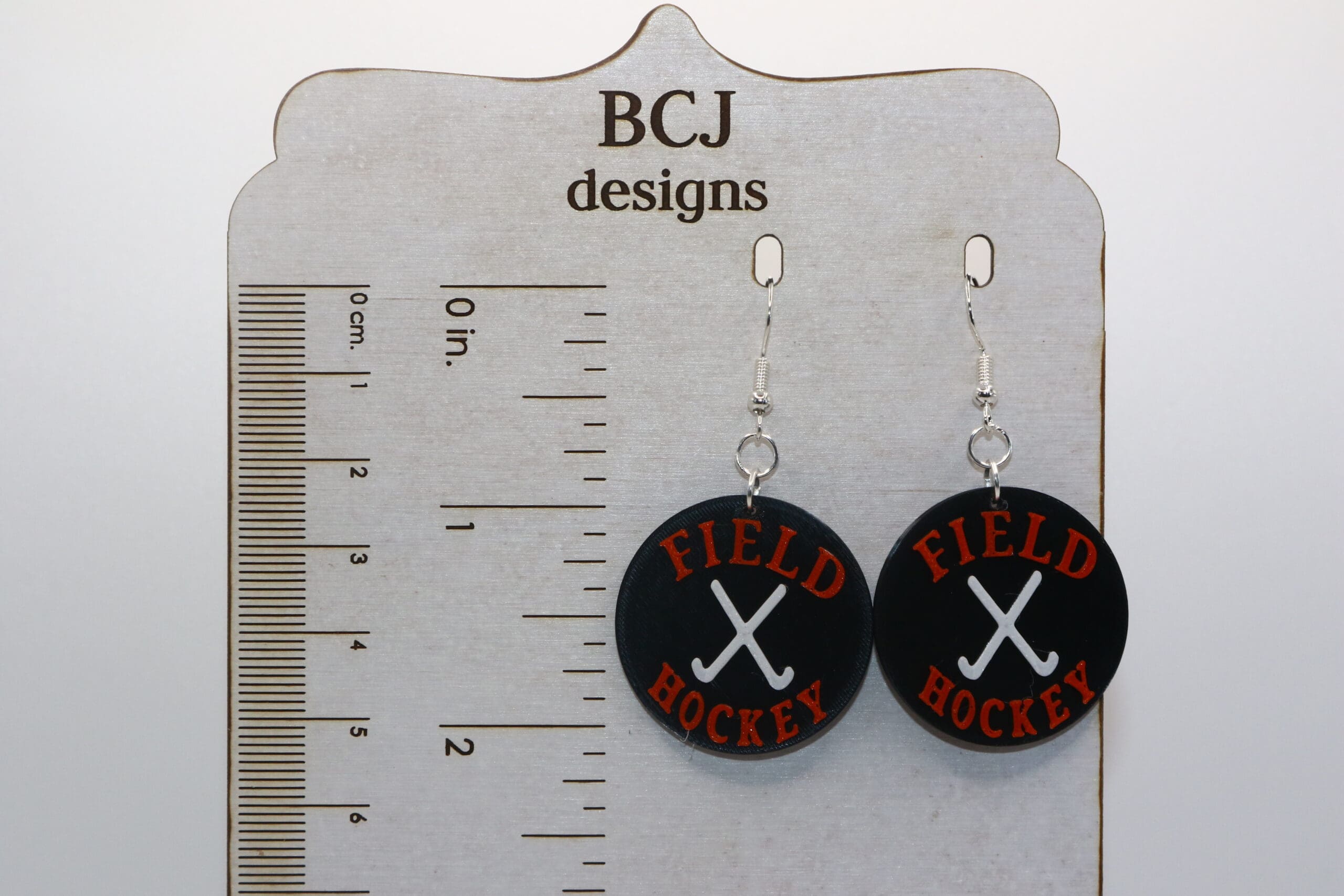 Field hockey earrings with orange and black sticks for Rising Sun High School