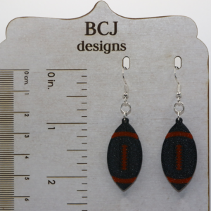 Black and orange football earrings representing Rising Sun High School spirit