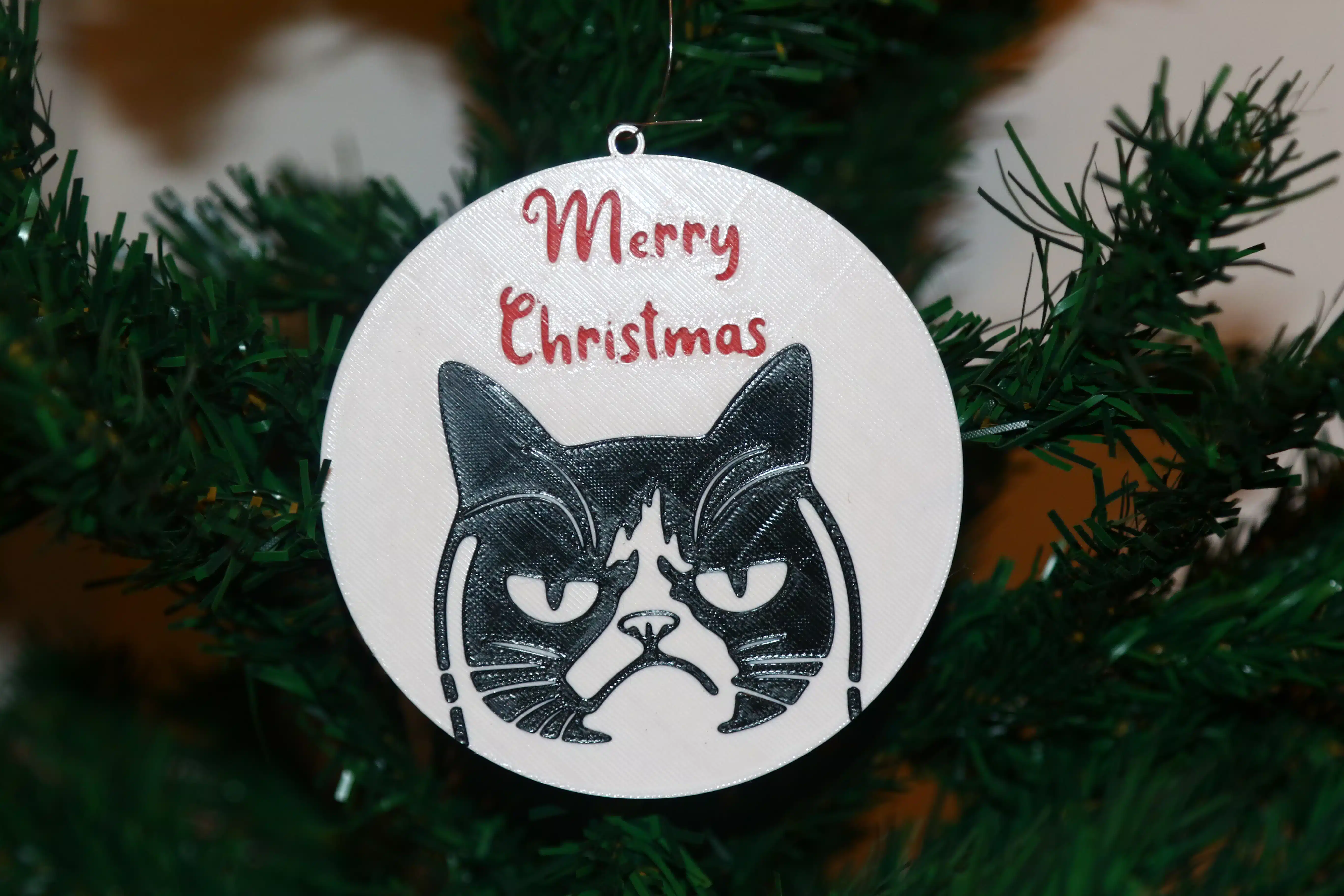 Grumpy Cat Christmas ornament with text “Merry Christmas,” colorful holiday theme.