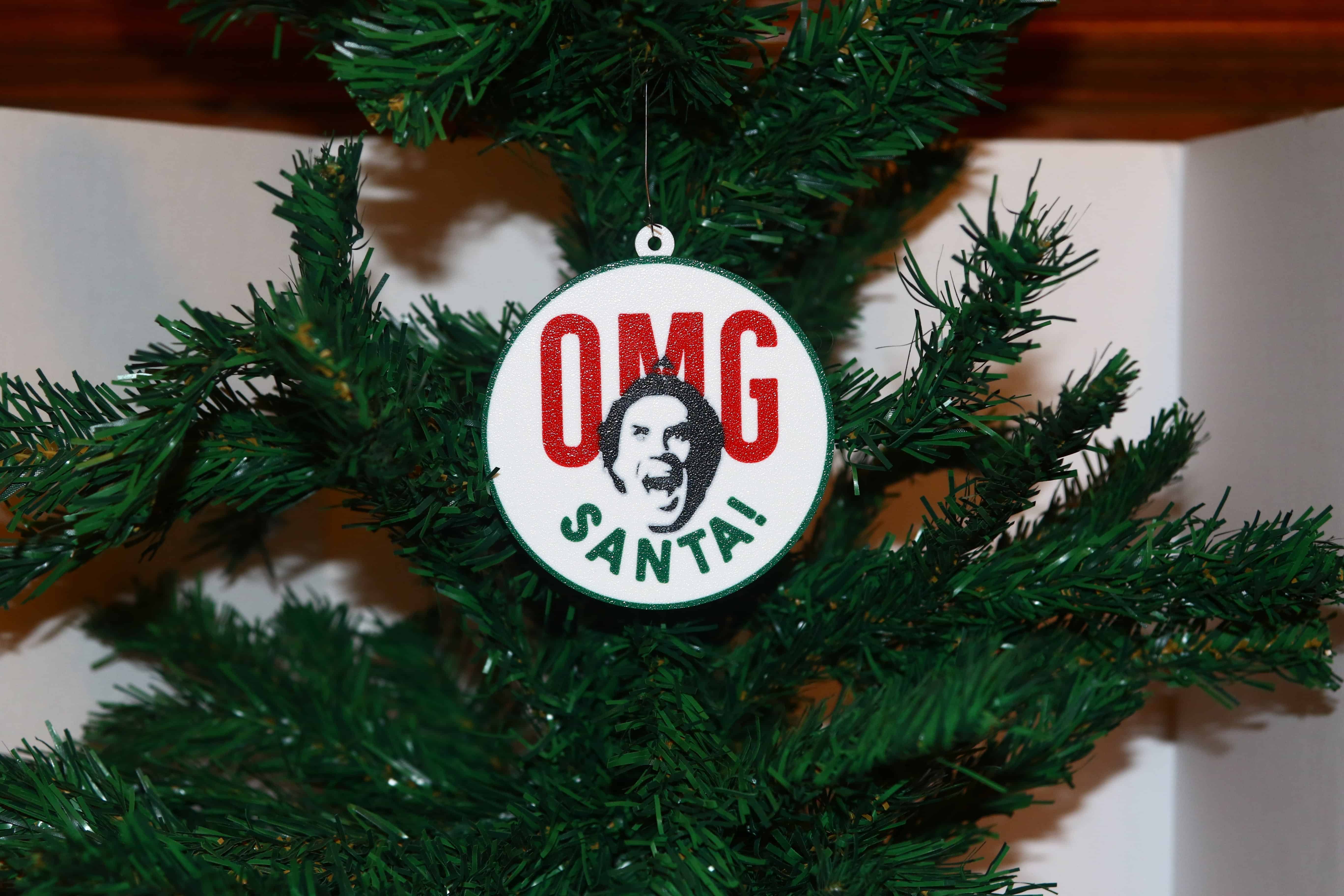 Elf Christmas ornament with Buddy’s shocked “OMG Santa” expression, festive design.