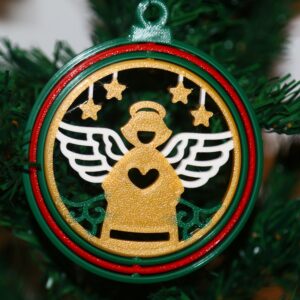 Angel Christmas ornament holding a heart with surrounding stars, colorful festive design.