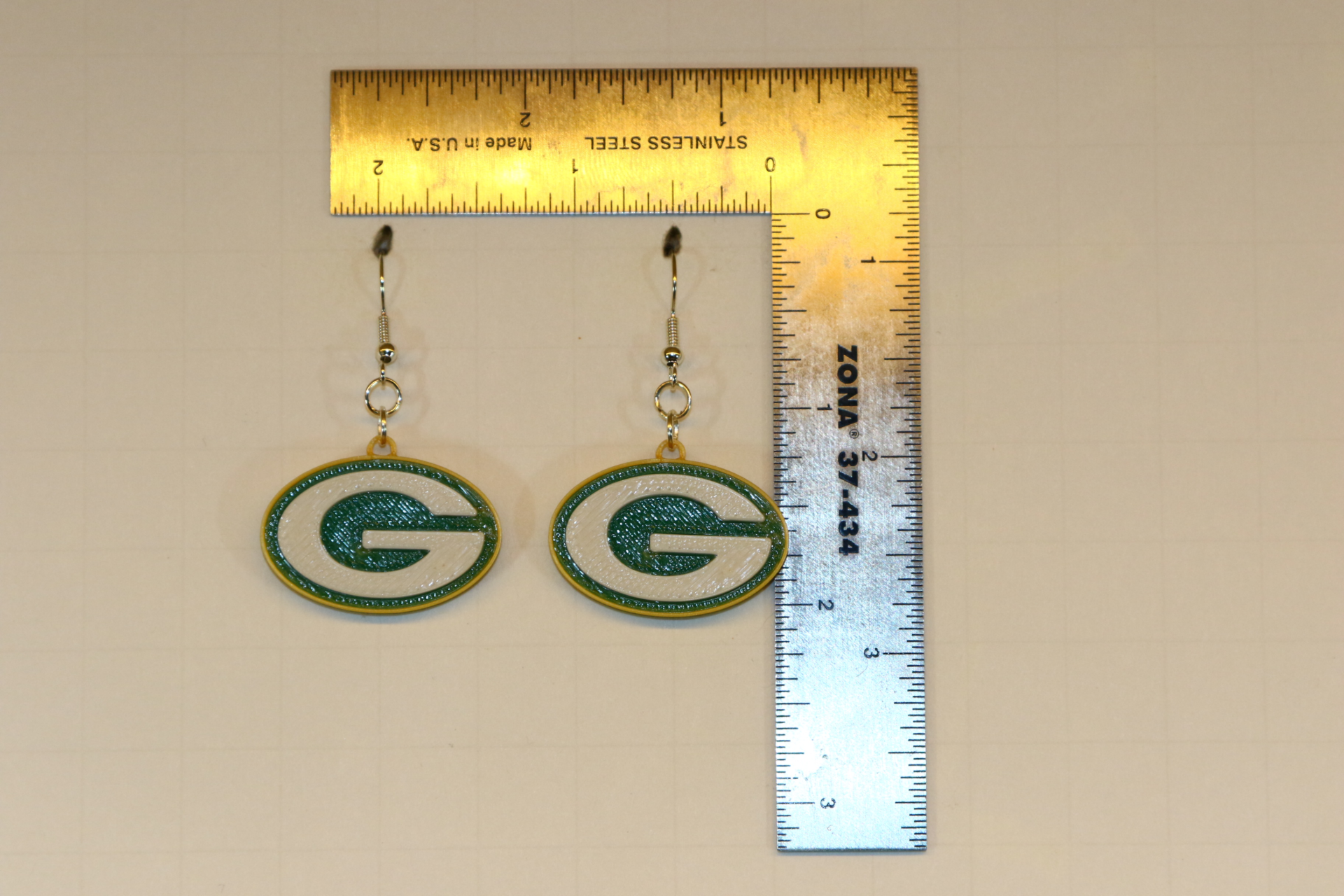 Pair of earrings featuring the Green Bay Packers “G” logo in green and gold.