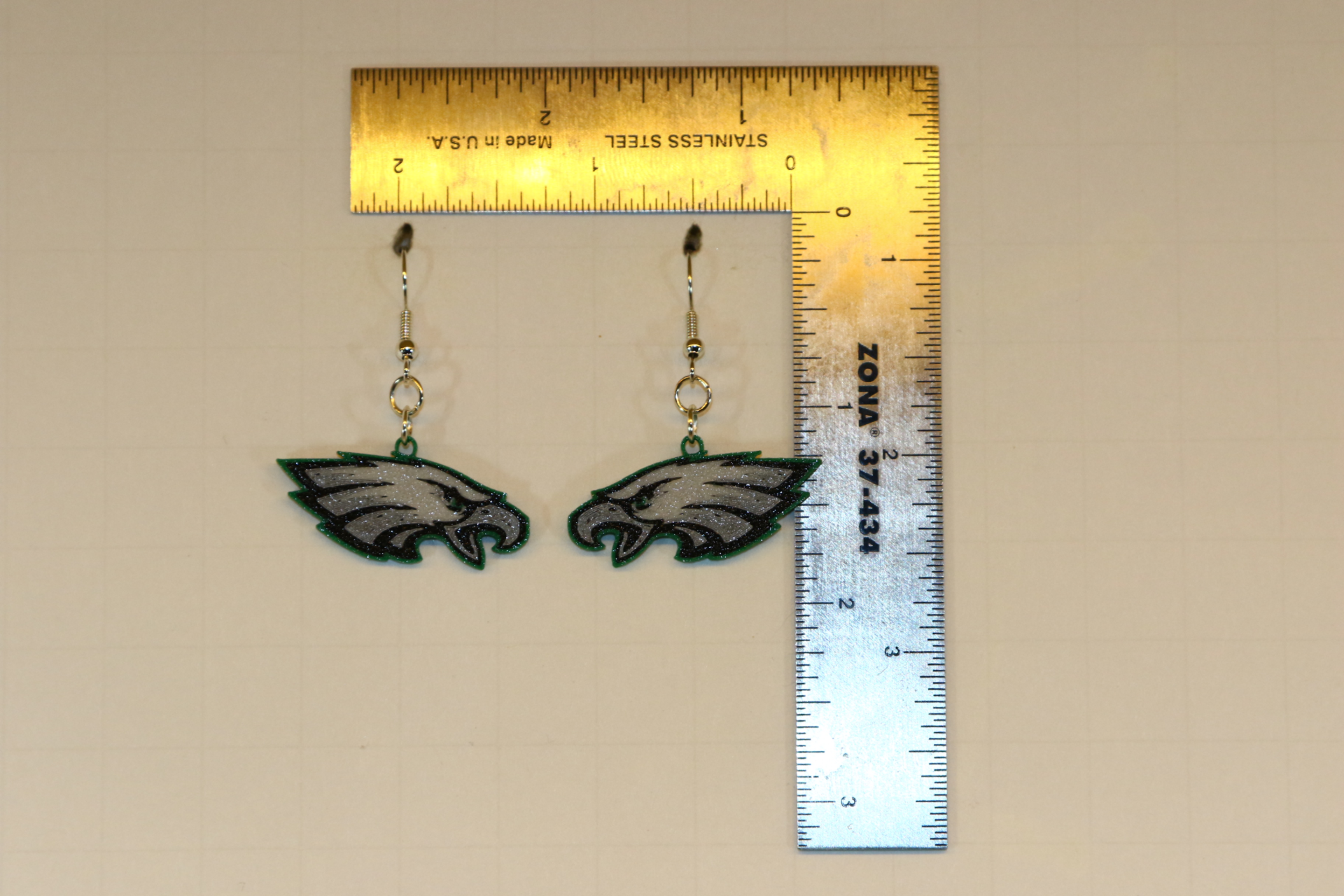 Pair of earrings featuring the Philadelphia Eagles logo in green, white, and black.