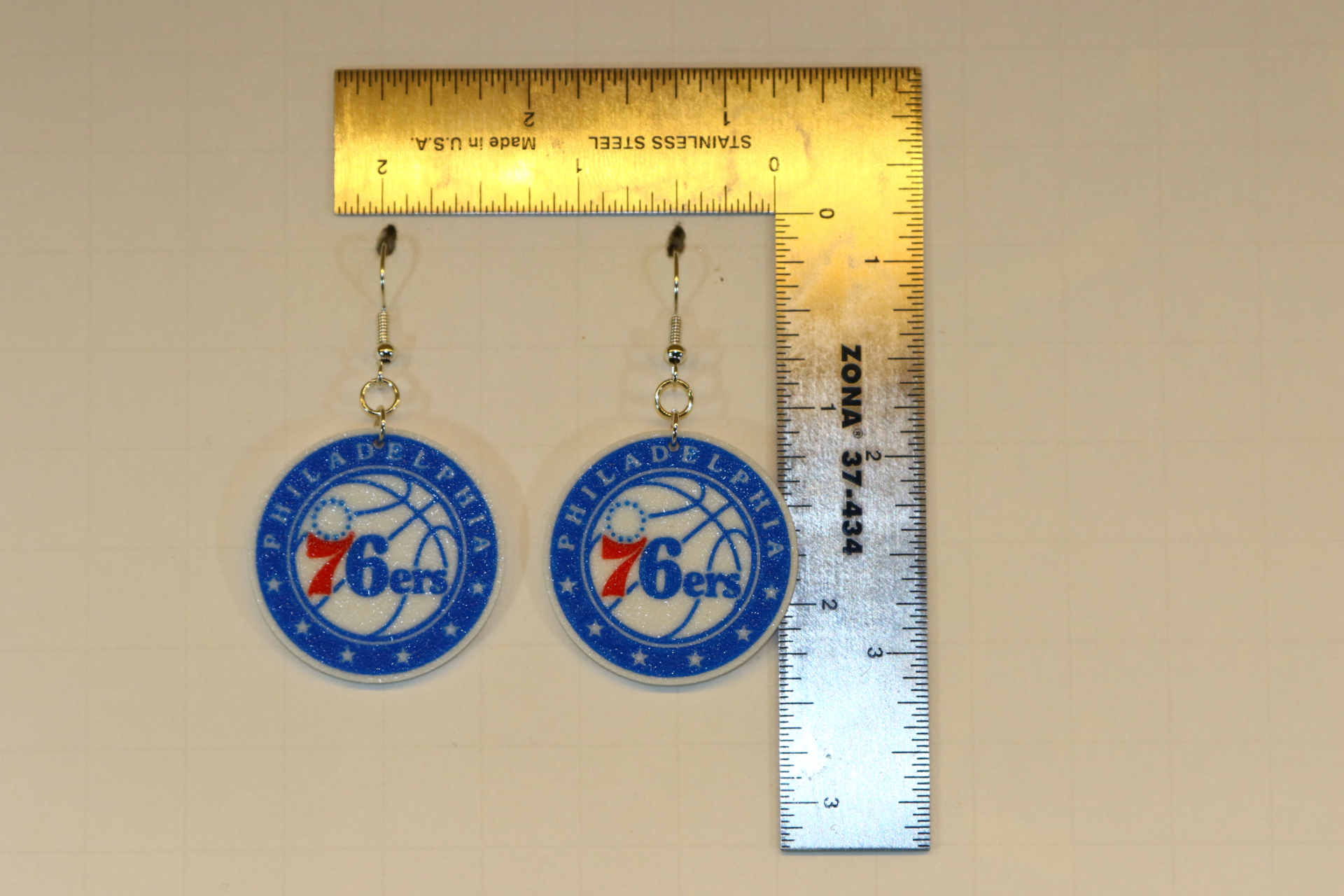 Pair of earrings featuring the Philadelphia 76ers logo in red, white, and blue.