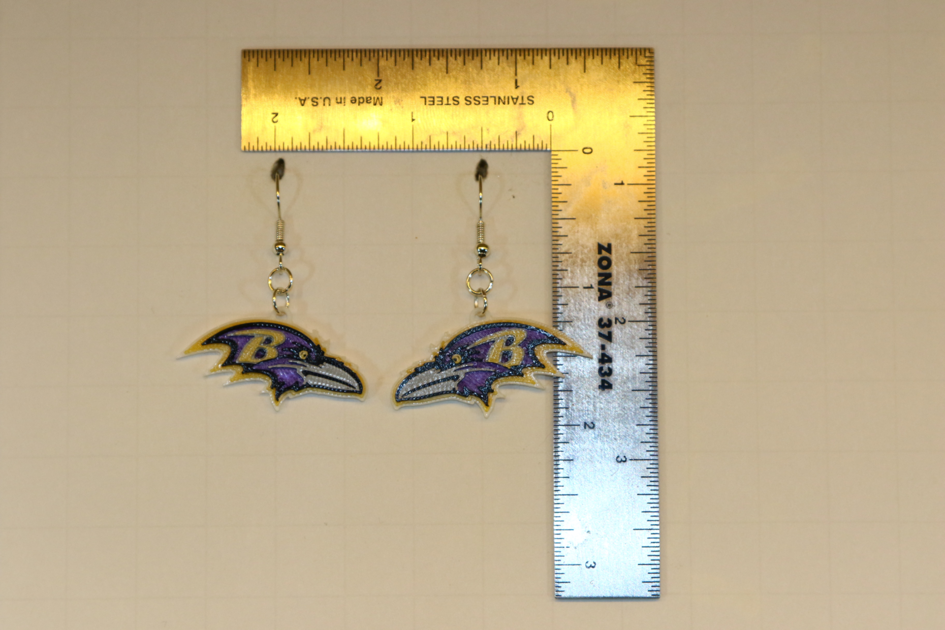Pair of earrings featuring the Baltimore Ravens logo in purple, black, and gold.