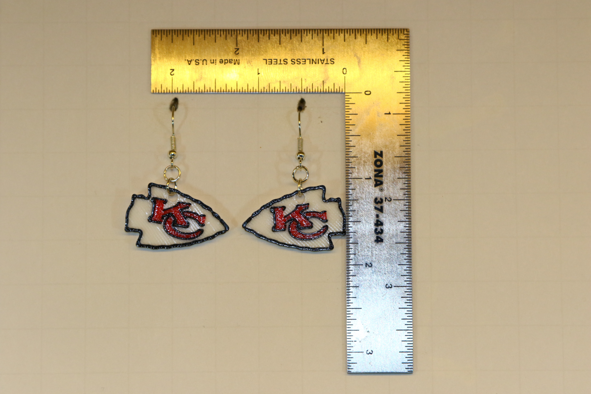 Pair of earrings featuring the Kansas City Chiefs logo in red, gold, and white.